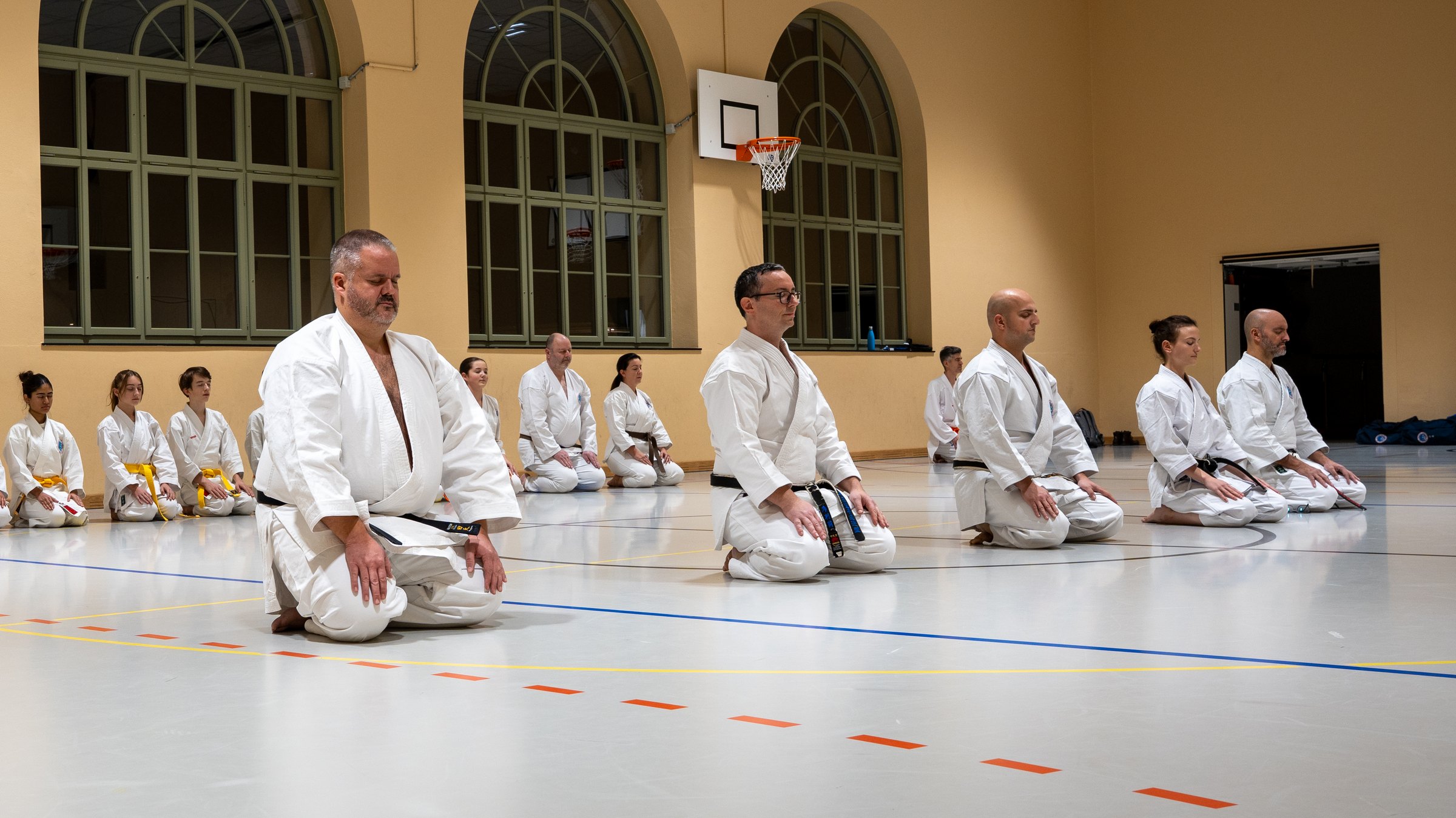 Seiza im Dojo Lind Nord: Senseis und Karatekas knien in der Turnhalle